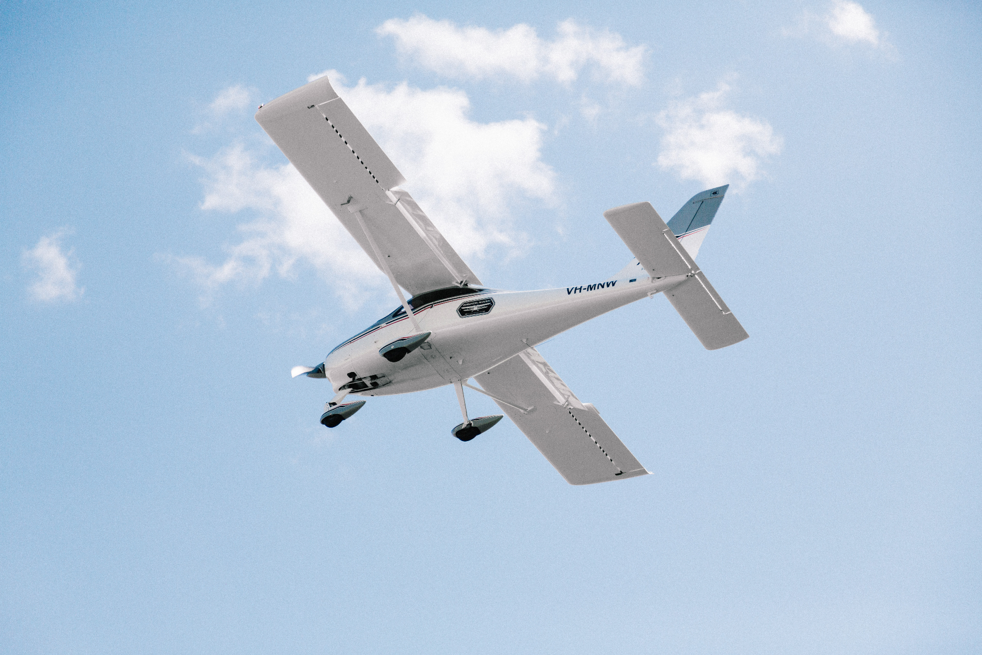 Tecnam training aircraft in flight against a blue sky